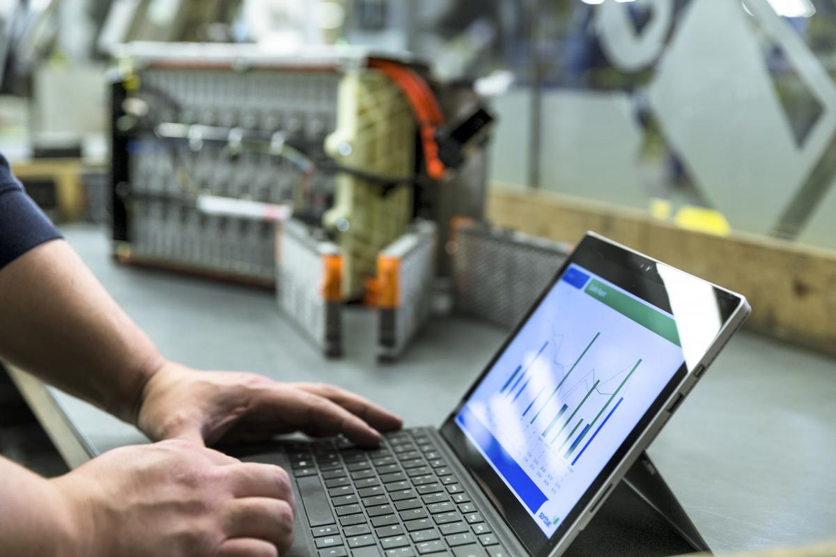 guy on computer in a car workshop