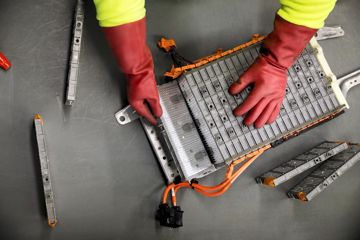 guy dismantling electric car battery