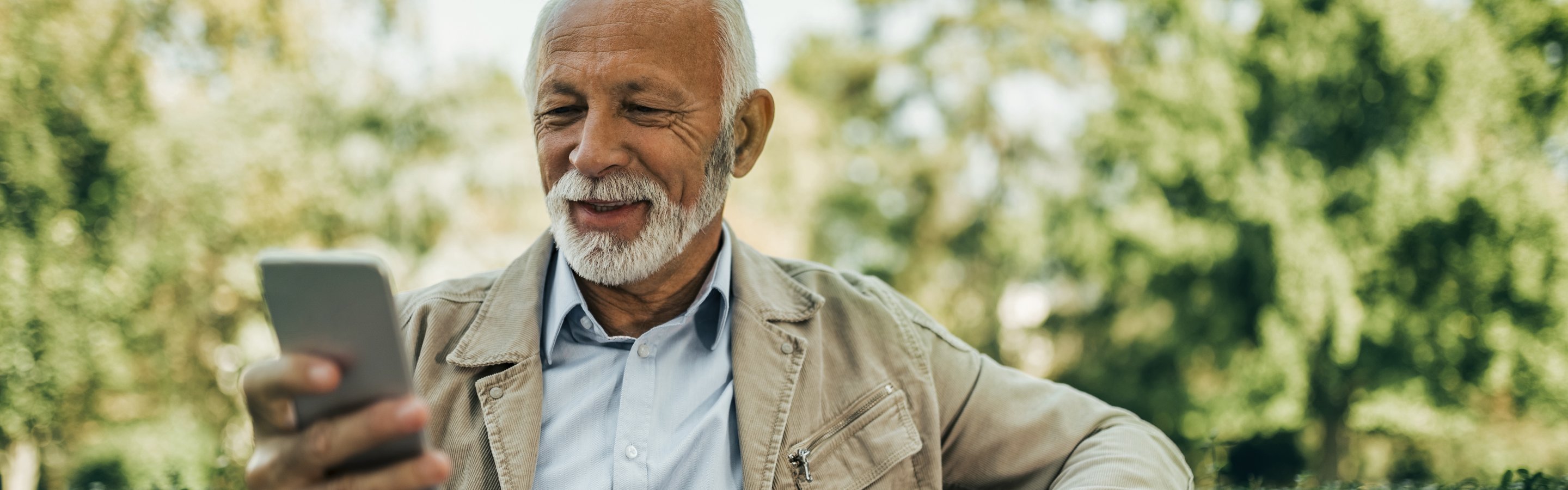 old guy holding phone on bench